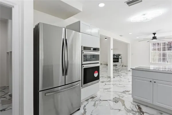 a kitchen with stainless steel appliances granite countertop a refrigerator and a sink