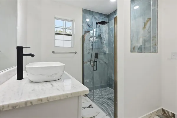 a bathroom with a granite countertop sink toilet and shower