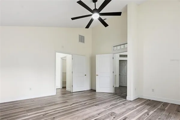 an empty room with wooden floor a ceiling fan and closet