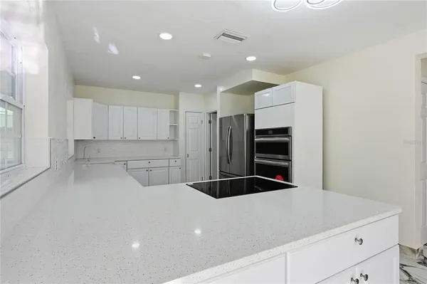 a kitchen with a refrigerator and white cabinets