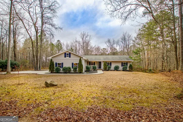 a front view of house with yard and trees around