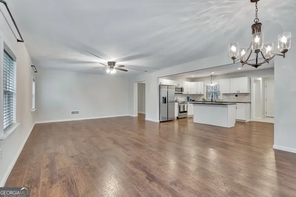 a kitchen with granite countertop a sink and dishwasher a stove with wooden floor