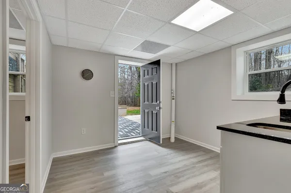 an empty room with wooden floor fan and windows