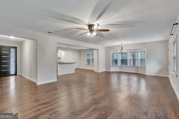 a living room with furniture chandelier and view of kitchen