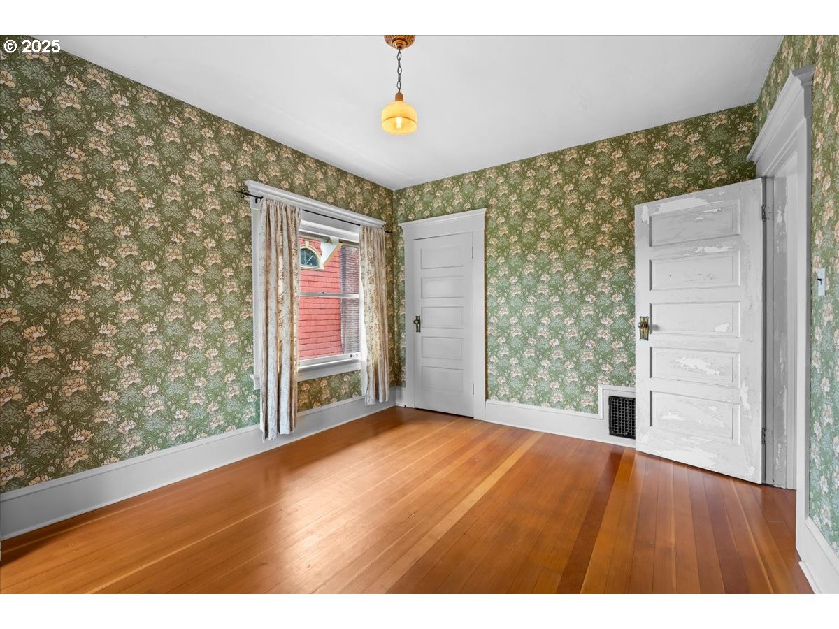 1844 Southeast 12th Avenue Portland, OR 97214 - Photo 19 of 48 a view of an empty room with wooden floor and a window