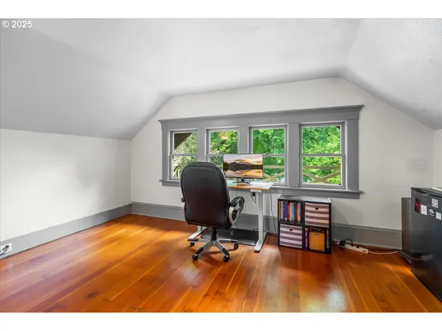 a view of hallway with a large window and wooden floor