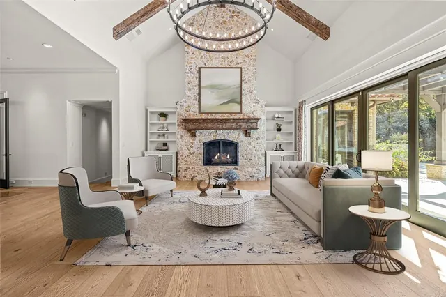 a living room with fireplace furniture and a large window