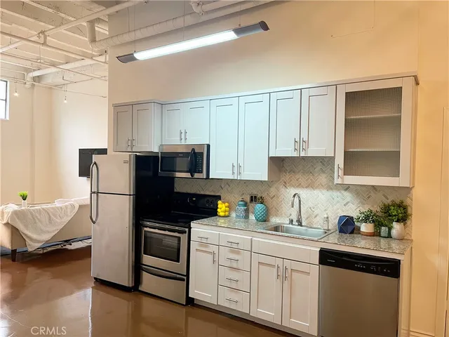 a kitchen with a refrigerator and white cabinets
