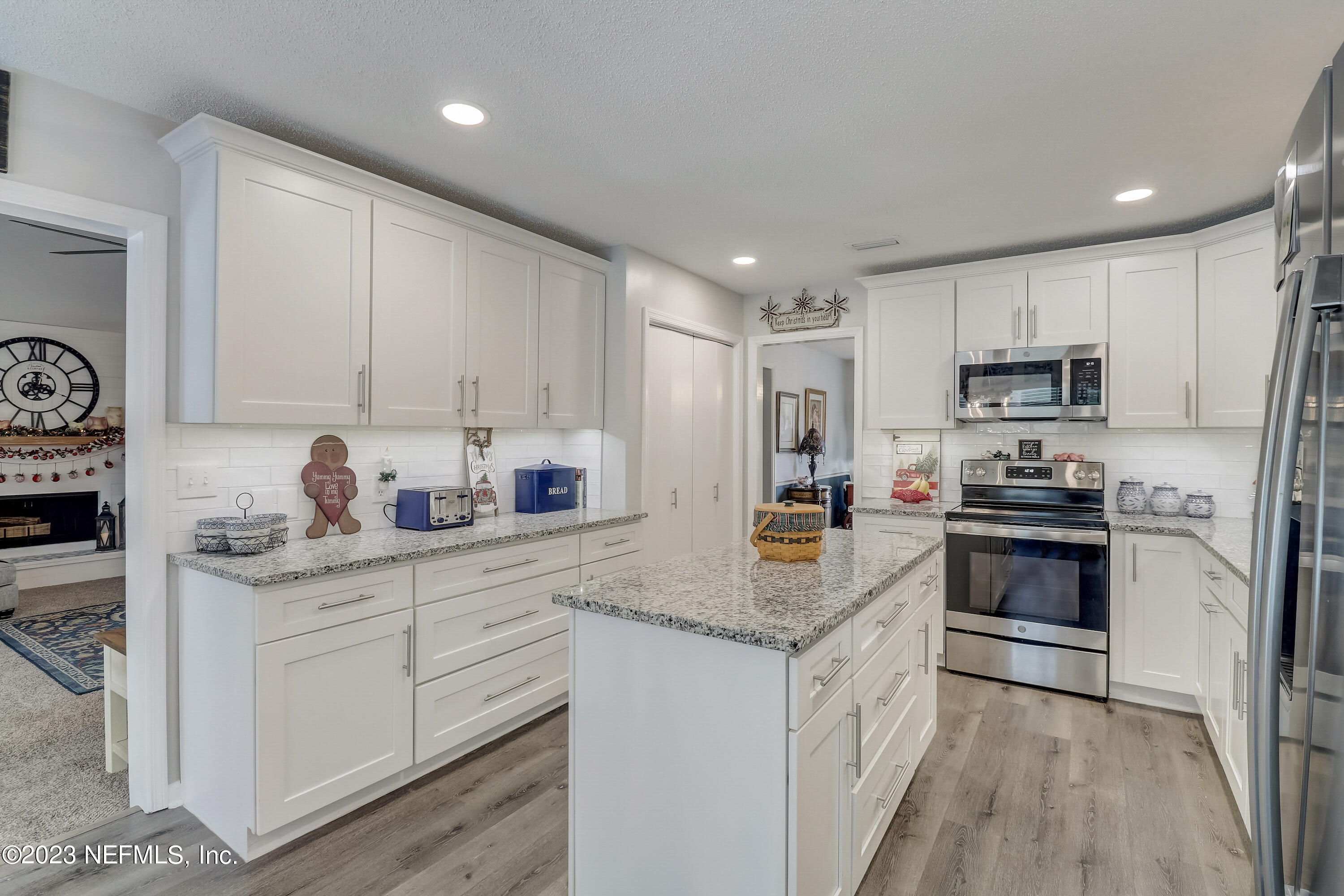 55377 Deer Run Road Callahan, FL 32011 - Photo 11 of 47 a kitchen with granite countertop white cabinets and white appliances