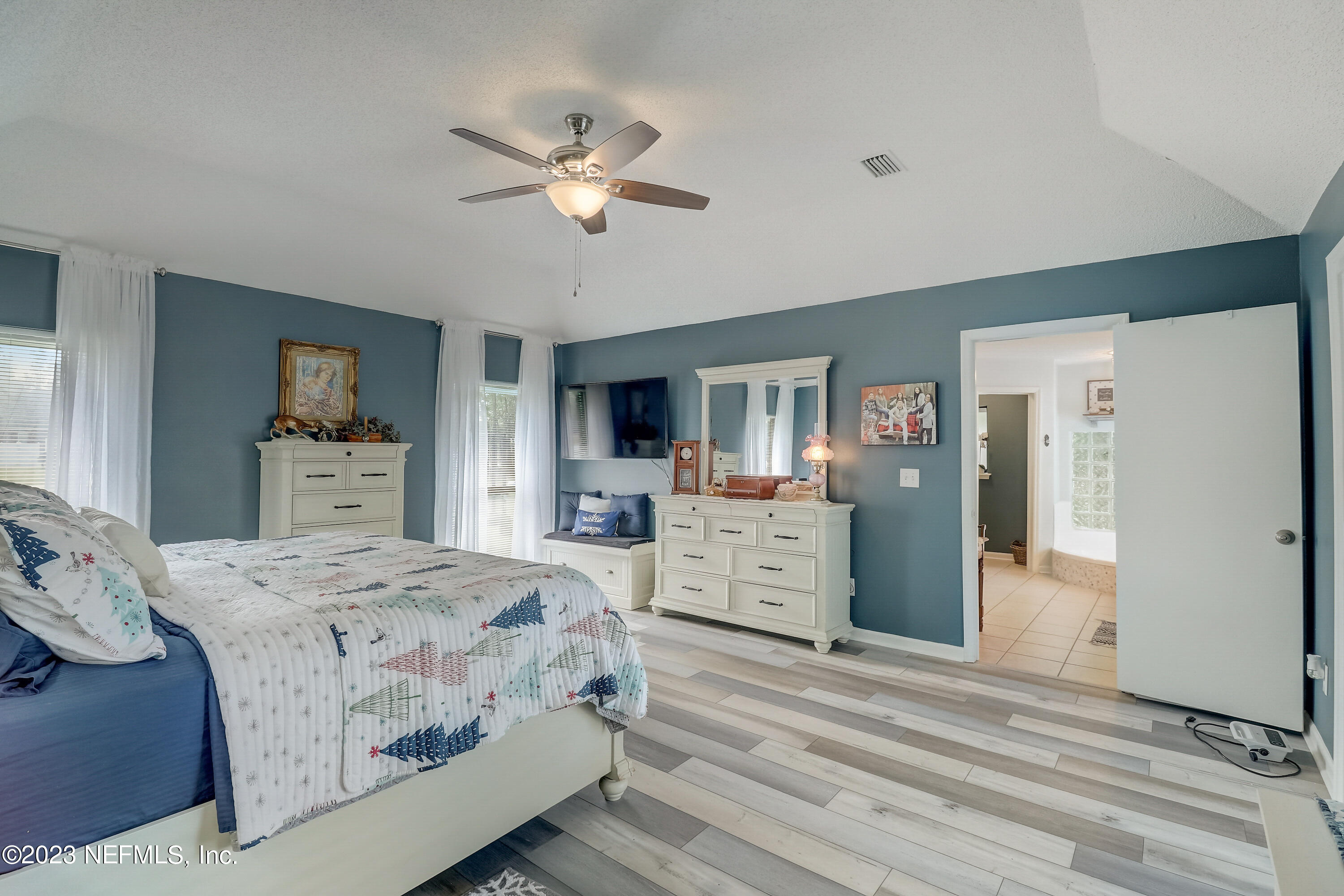 55377 Deer Run Road Callahan, FL 32011 - Photo 24 of 47 a bedroom with a large bed and a chandelier