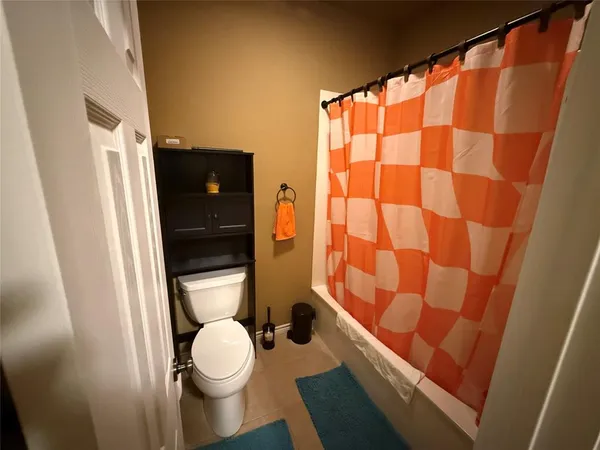 a bathroom with a toilet and a shower curtain