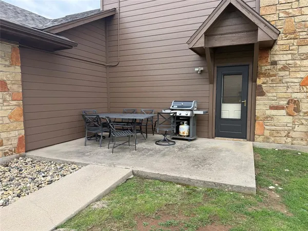 a backyard of a house with table and chairs