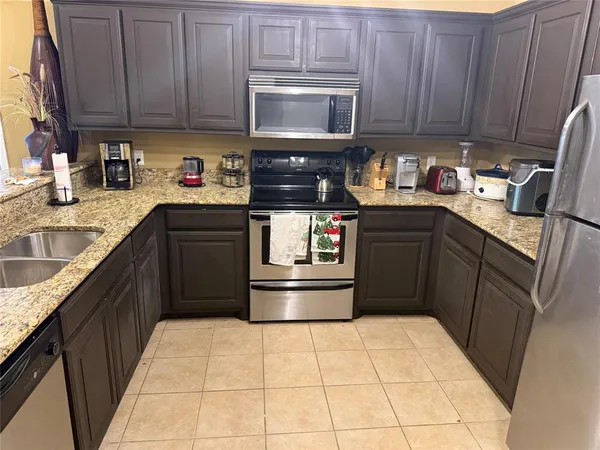 a kitchen with stainless steel appliances granite countertop a stove sink and cabinets