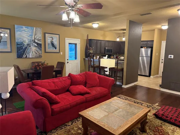 a living room with furniture a table and kitchen view