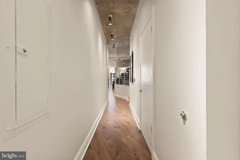 a view of a hallway with wooden floor and staircase