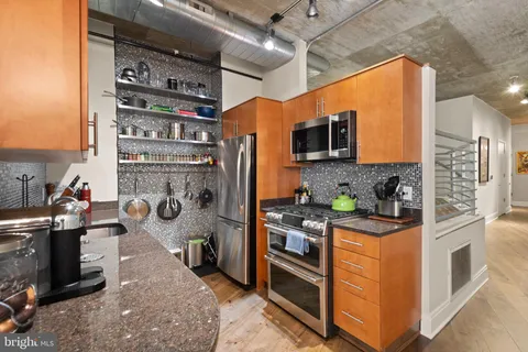 a kitchen with stainless steel appliances granite countertop a stove and cabinets