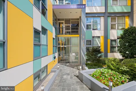 a view of a brick house with a large windows and a flower plants