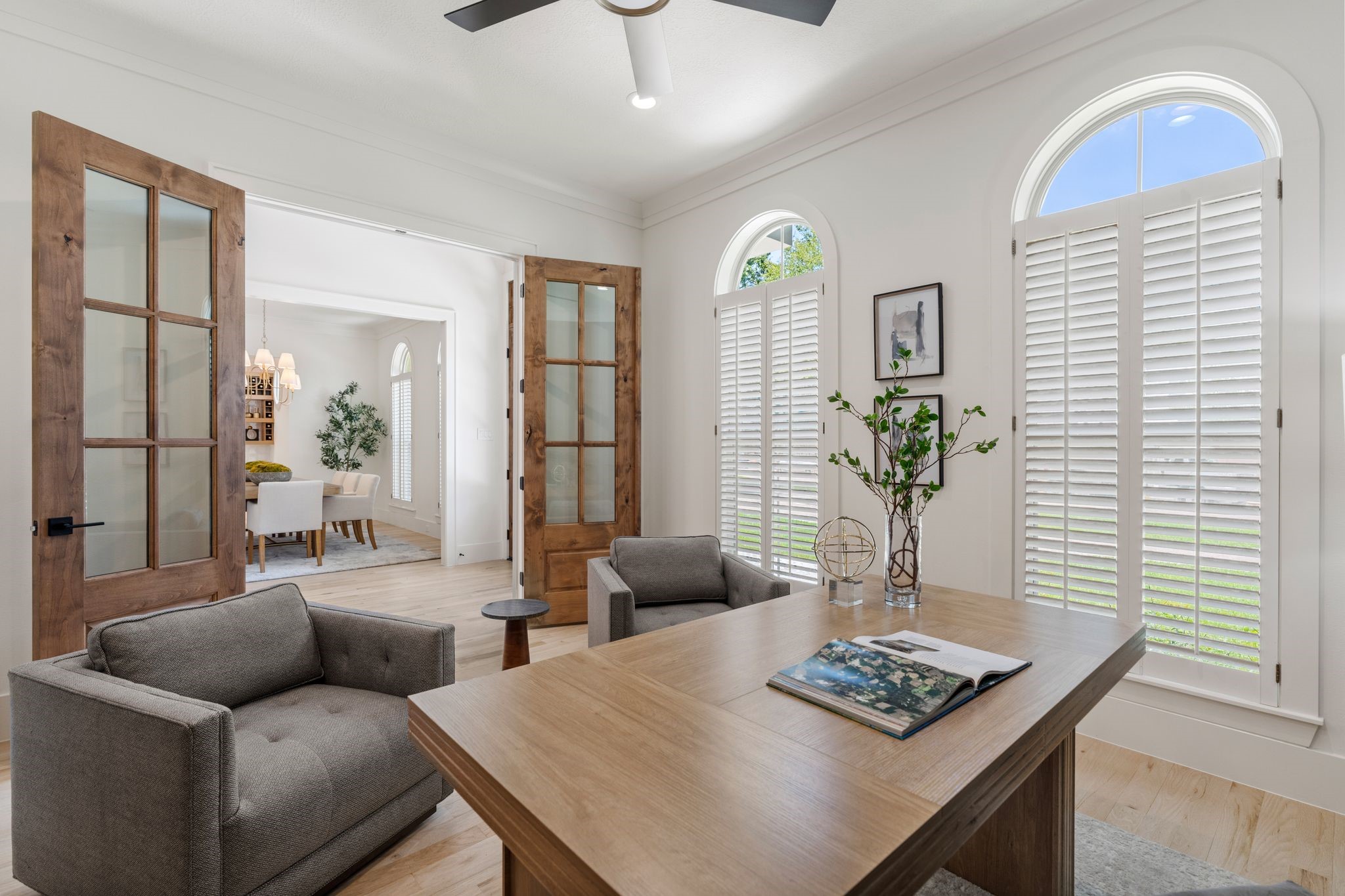 31 Hollymead Drive Spring, TX 77381 - Photo 8 of 50 This home office has elegant wooden French doors, arched windows with custom shutters. The room flows into a dining area, creating an inviting and functional space.