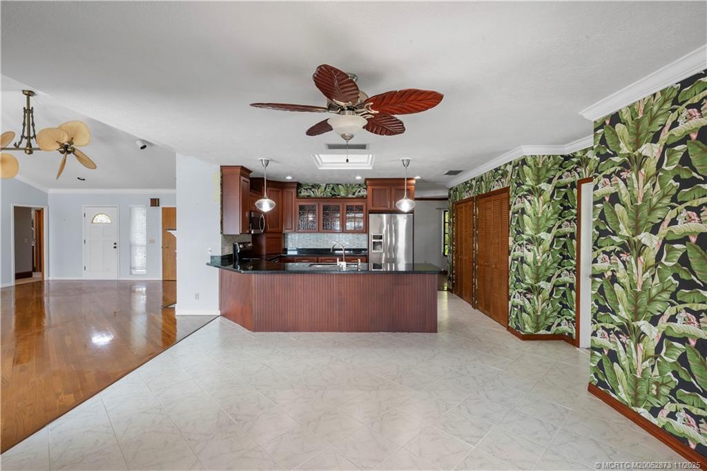 969 Southeast St Lucie Boulevard Stuart, FL 34996 - Photo 14 of 49 a kitchen with stainless steel appliances kitchen island granite countertop a refrigerator a stove and a wooden floor