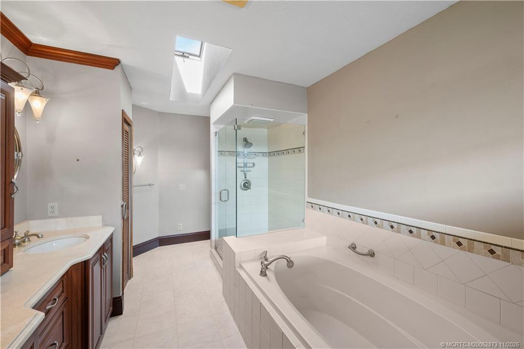 969 Southeast St Lucie Boulevard Stuart, FL 34996 - Photo 26 of 49 a spacious bathroom with a tub sink and mirror