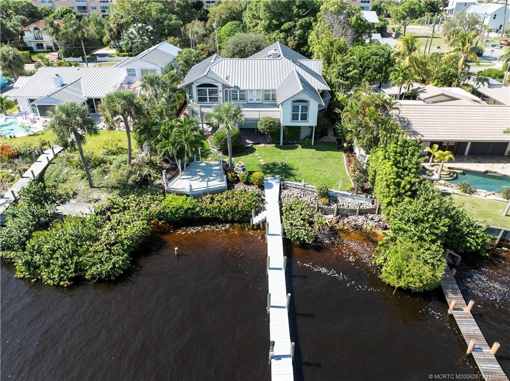 969 Southeast St Lucie Boulevard Stuart, FL 34996 - Photo 4 of 49 a front view of a house with a yard and garden