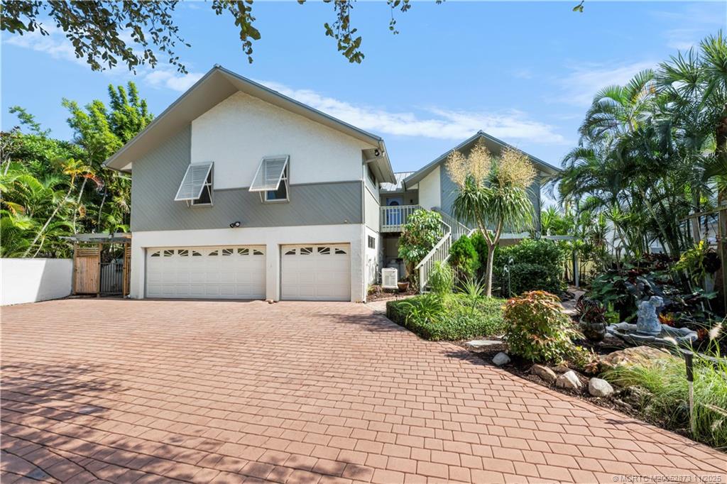 969 Southeast St Lucie Boulevard Stuart, FL 34996 - Photo 47 of 49 a front view of a house with a yard and garage