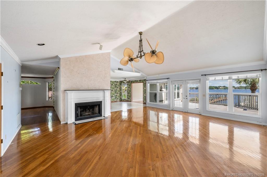 969 Southeast St Lucie Boulevard Stuart, FL 34996 - Photo 8 of 49 a view of an empty room with wooden floor fireplace and a window