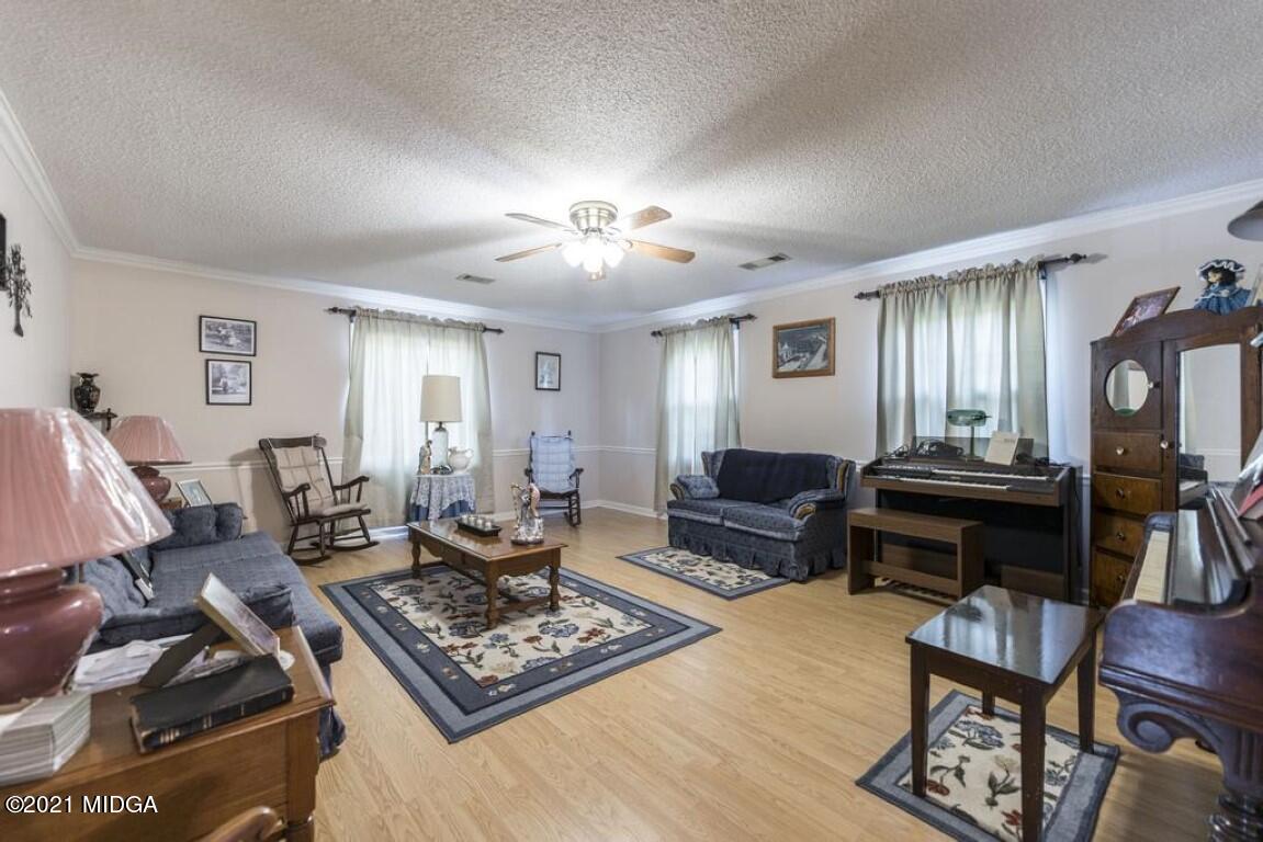 1471 Woolfolk Road Fort Valley, GA 31030 - Photo 18 of 51 a living room with furniture a wooden floor and a lamp