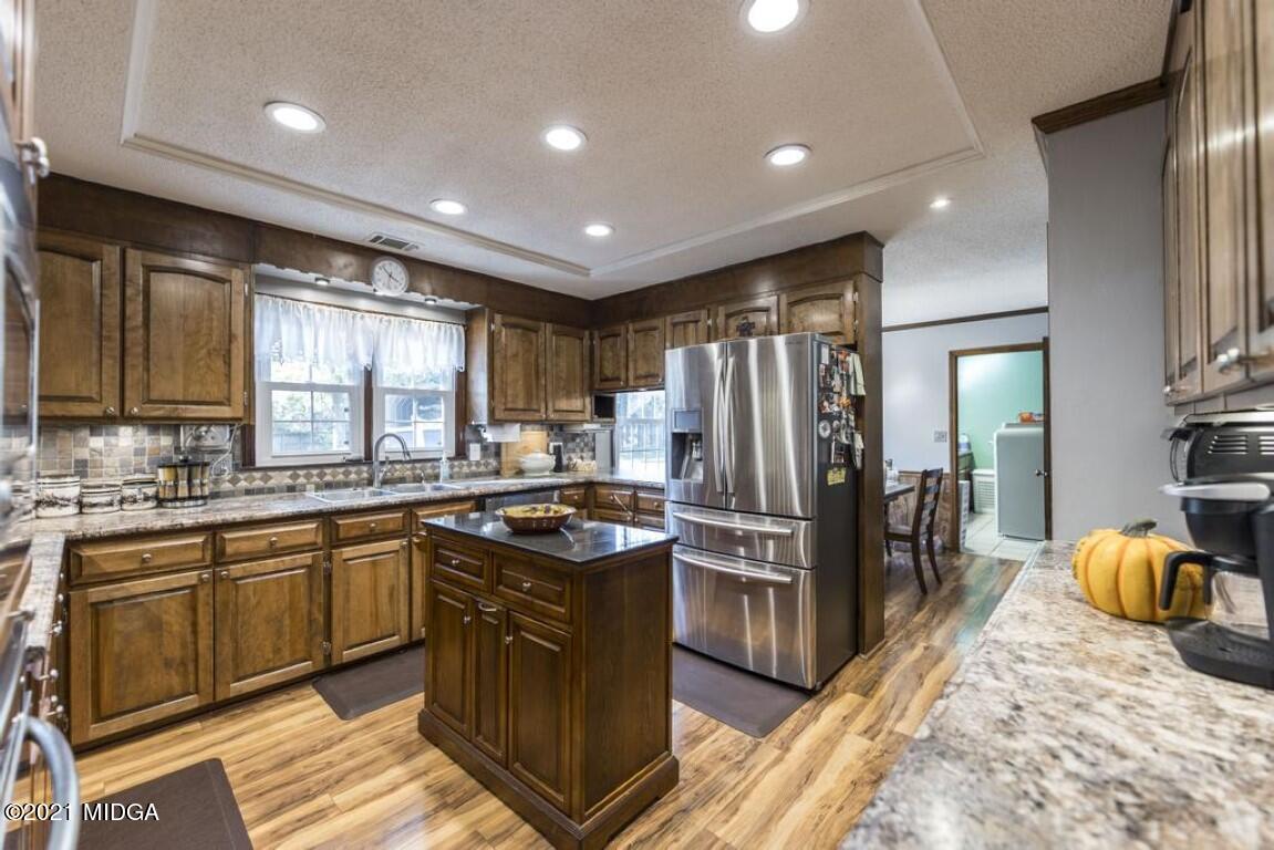 1471 Woolfolk Road Fort Valley, GA 31030 - Photo 20 of 51 a kitchen with stainless steel appliances granite countertop sink stove refrigerator and cabinets