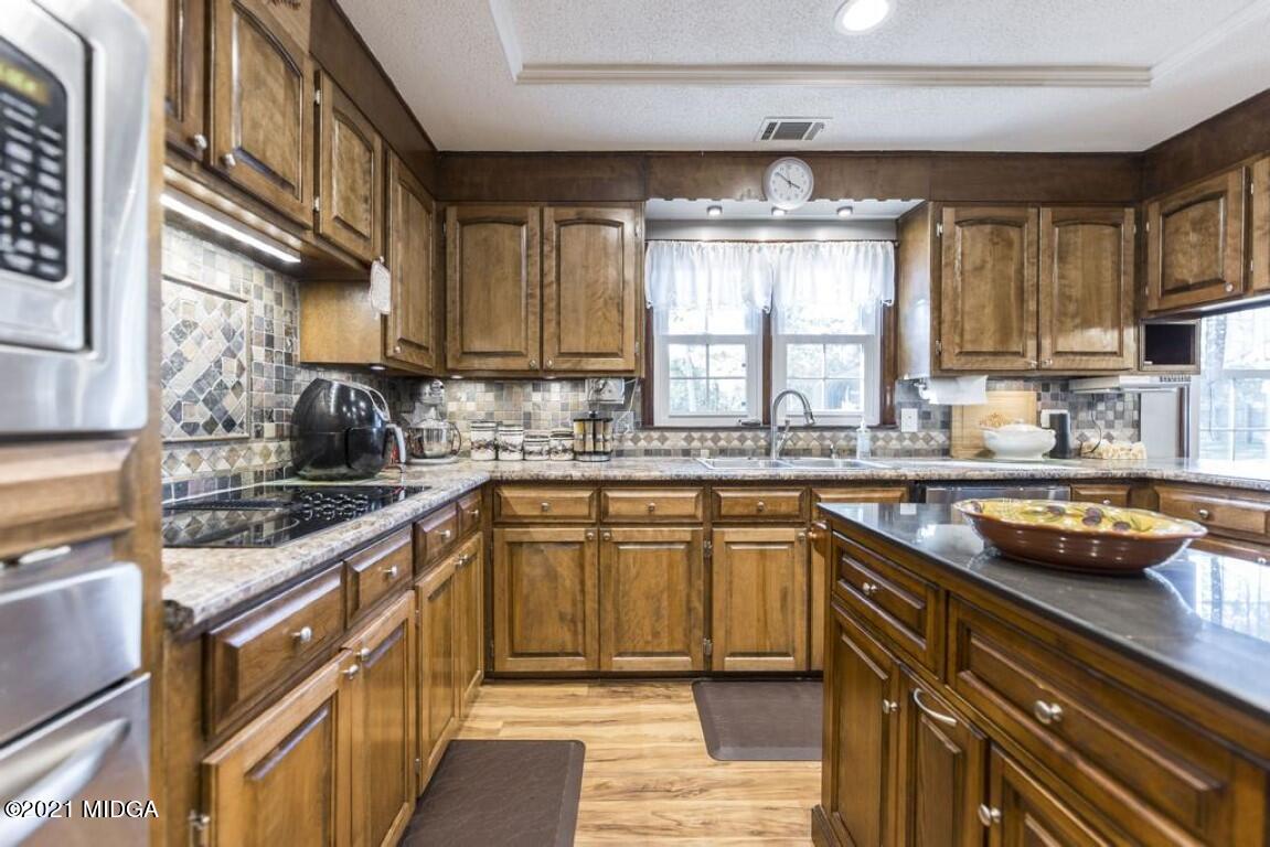1471 Woolfolk Road Fort Valley, GA 31030 - Photo 21 of 51 a kitchen with stainless steel appliances granite countertop a sink stove and cabinets