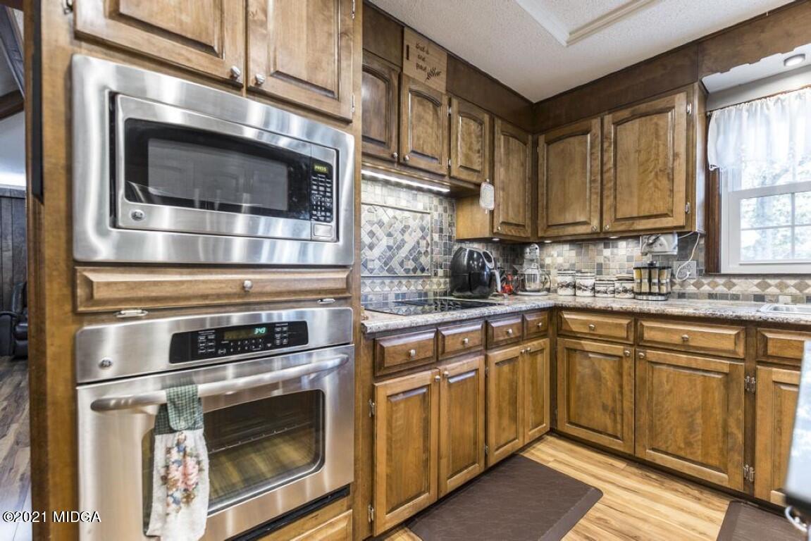 1471 Woolfolk Road Fort Valley, GA 31030 - Photo 22 of 51 a kitchen with granite countertop cabinets stainless steel appliances and window