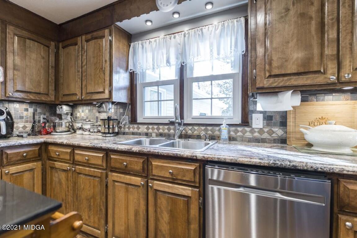 1471 Woolfolk Road Fort Valley, GA 31030 - Photo 23 of 51 a kitchen with stainless steel appliances granite countertop a sink stove and cabinets