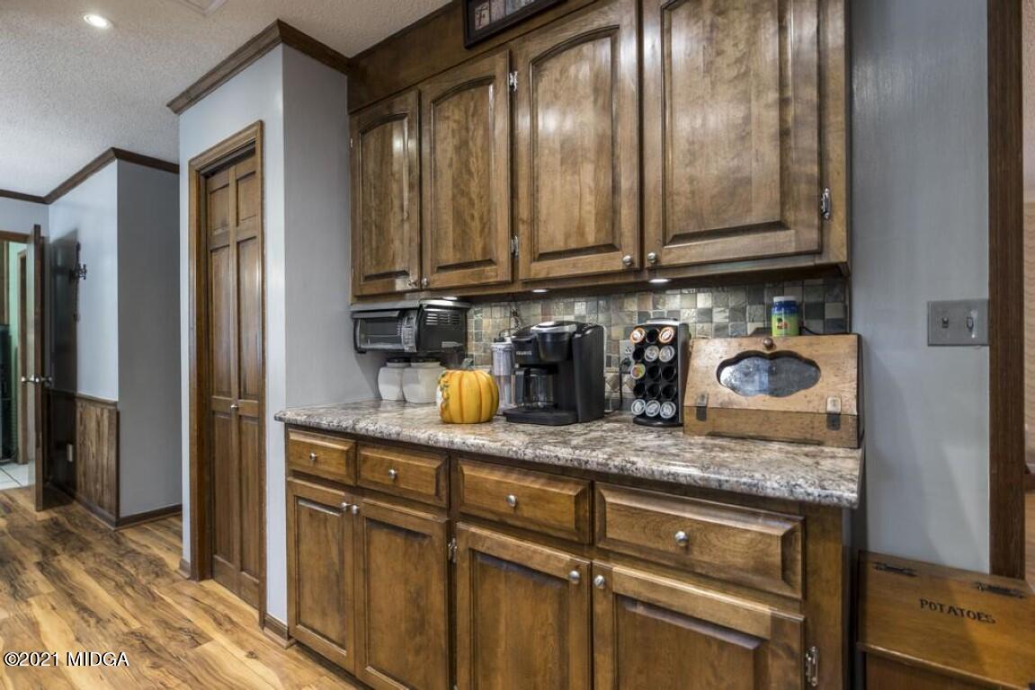 1471 Woolfolk Road Fort Valley, GA 31030 - Photo 25 of 51 a kitchen with granite countertop stainless steel appliances a sink and cabinets