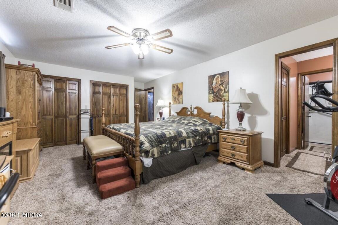 1471 Woolfolk Road Fort Valley, GA 31030 - Photo 36 of 51 a bedroom with a bed and a chandelier