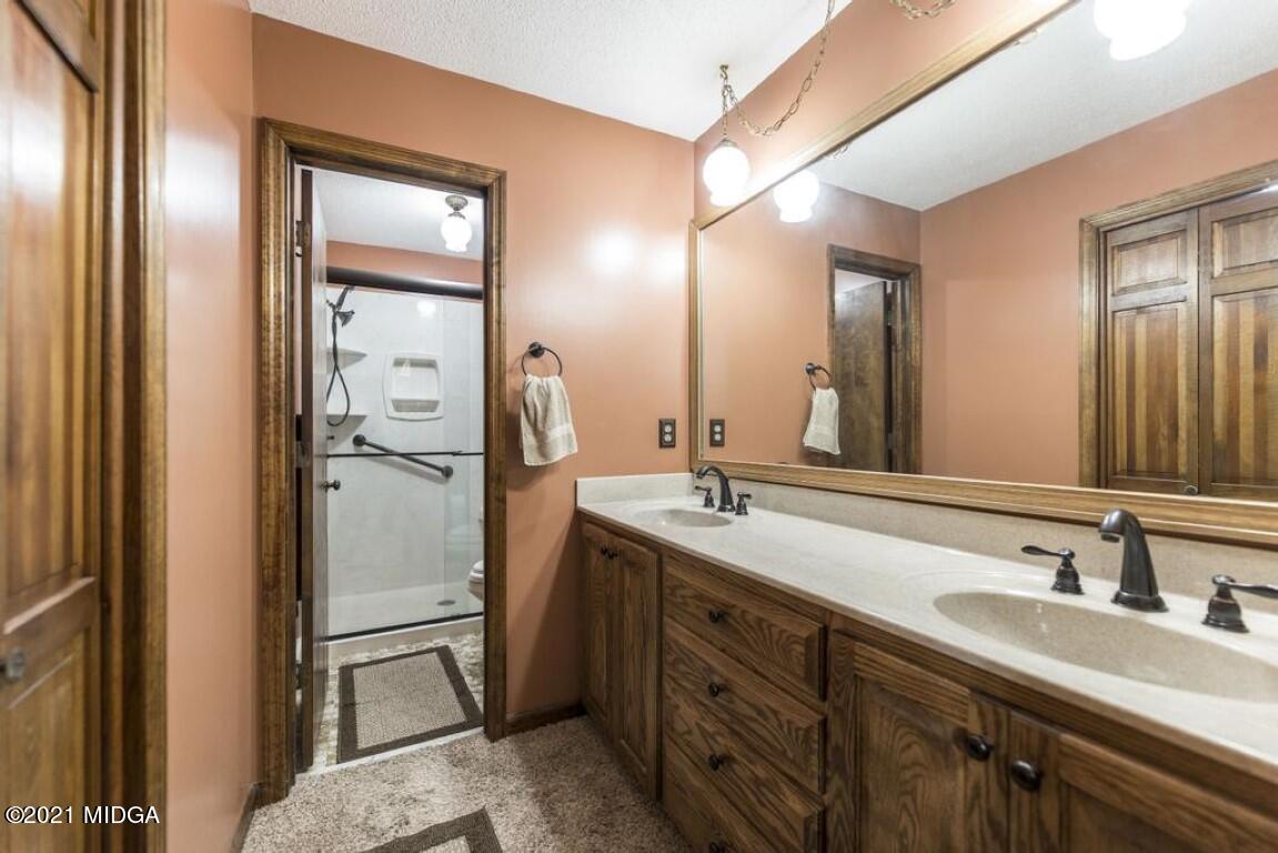 1471 Woolfolk Road Fort Valley, GA 31030 - Photo 38 of 51 a bathroom with a double vanity sink and mirror