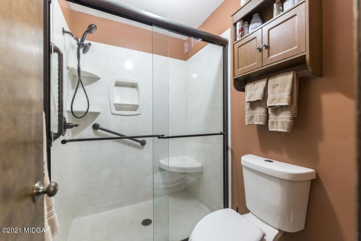 1471 Woolfolk Road Fort Valley, GA 31030 - Photo 39 of 51 a bathroom with a granite countertop shower a toilet and a sink
