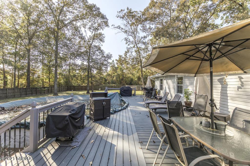1471 Woolfolk Road Fort Valley, GA 31030 - Photo 43 of 51 a view of a patio with table and chairs under an umbrella with wooden floor