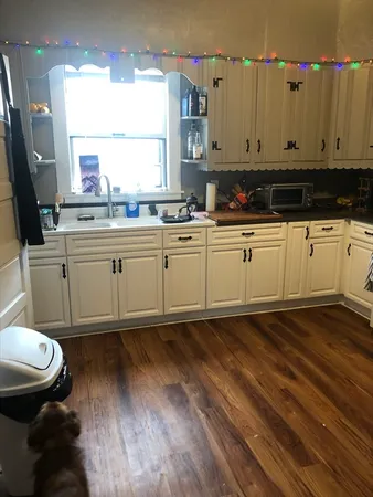 a kitchen with a sink cabinets and wooden floor