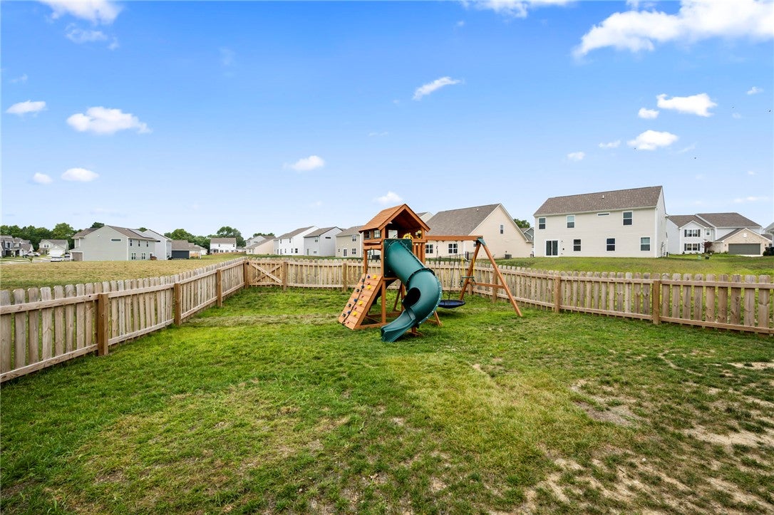 3011 Falls Road Clayton, OH 45315 - Photo 60 of 66 A fully fenced backyard with a playful swing set, ideal for family enjoyment.