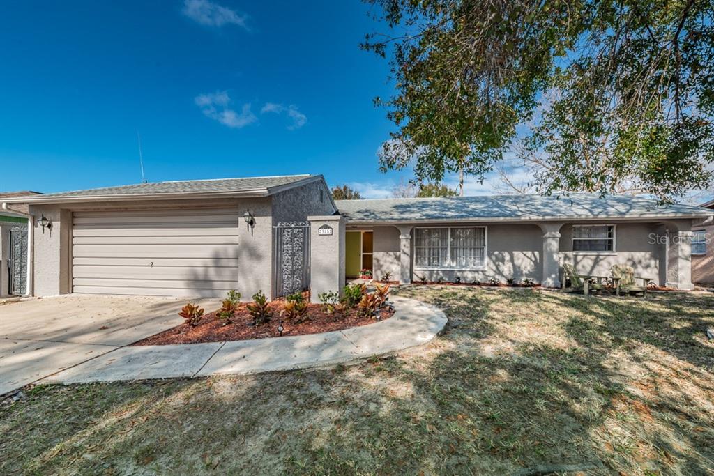 7315 Vienna Lane Port Richey, FL 34668 - Photo 1 of 1 a front view of house with yard outdoor seating and covered with trees