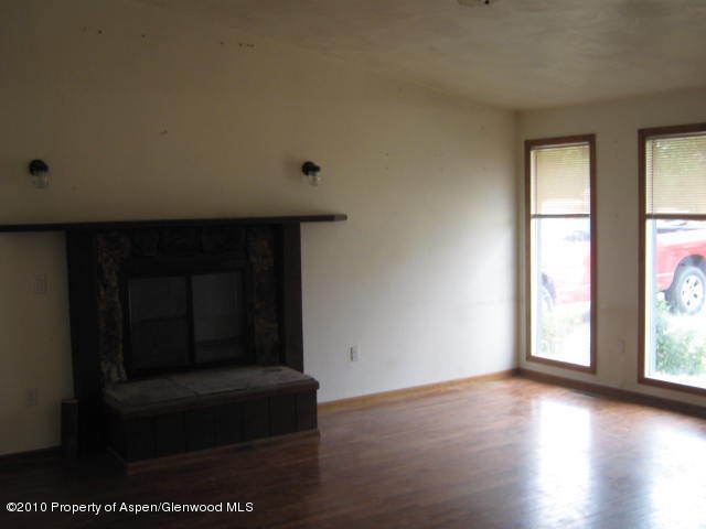 1001 West 5th Street Rifle, CO 81650 - Photo 5 of 5 an empty room with wooden floor and windows
