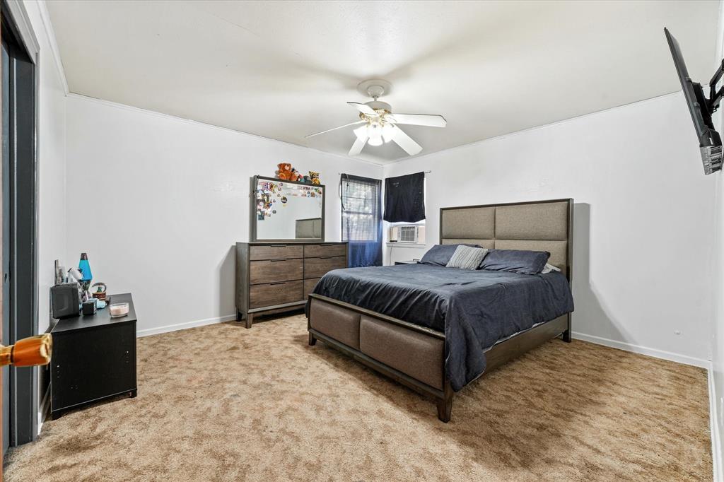 1100 North Church Street Decatur, TX 76234 - Photo 9 of 14 Carpeted room with a ceiling fan, white walls, and a window with dark curtains