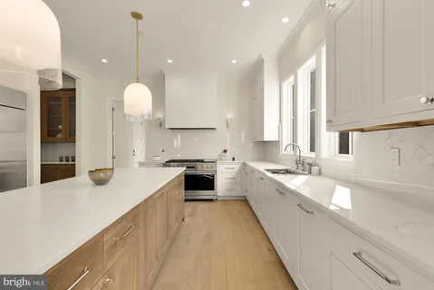 a large kitchen with stainless steel appliances kitchen island granite countertop a sink and cabinets