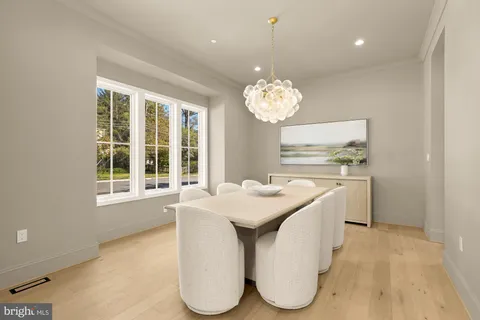 a dining room with chandelier and wooden floor