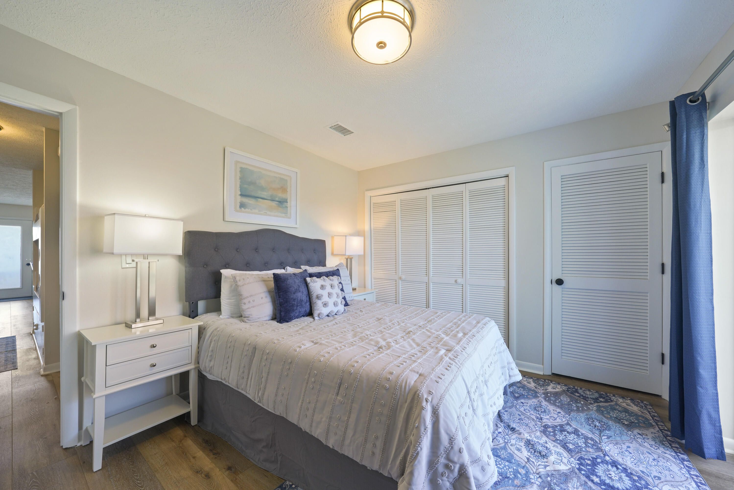 17670 Front Beach Road, Unit H9 Panama City Beach, FL 32413 - Photo 14 of 31 a bedroom with a bed and a lamp
