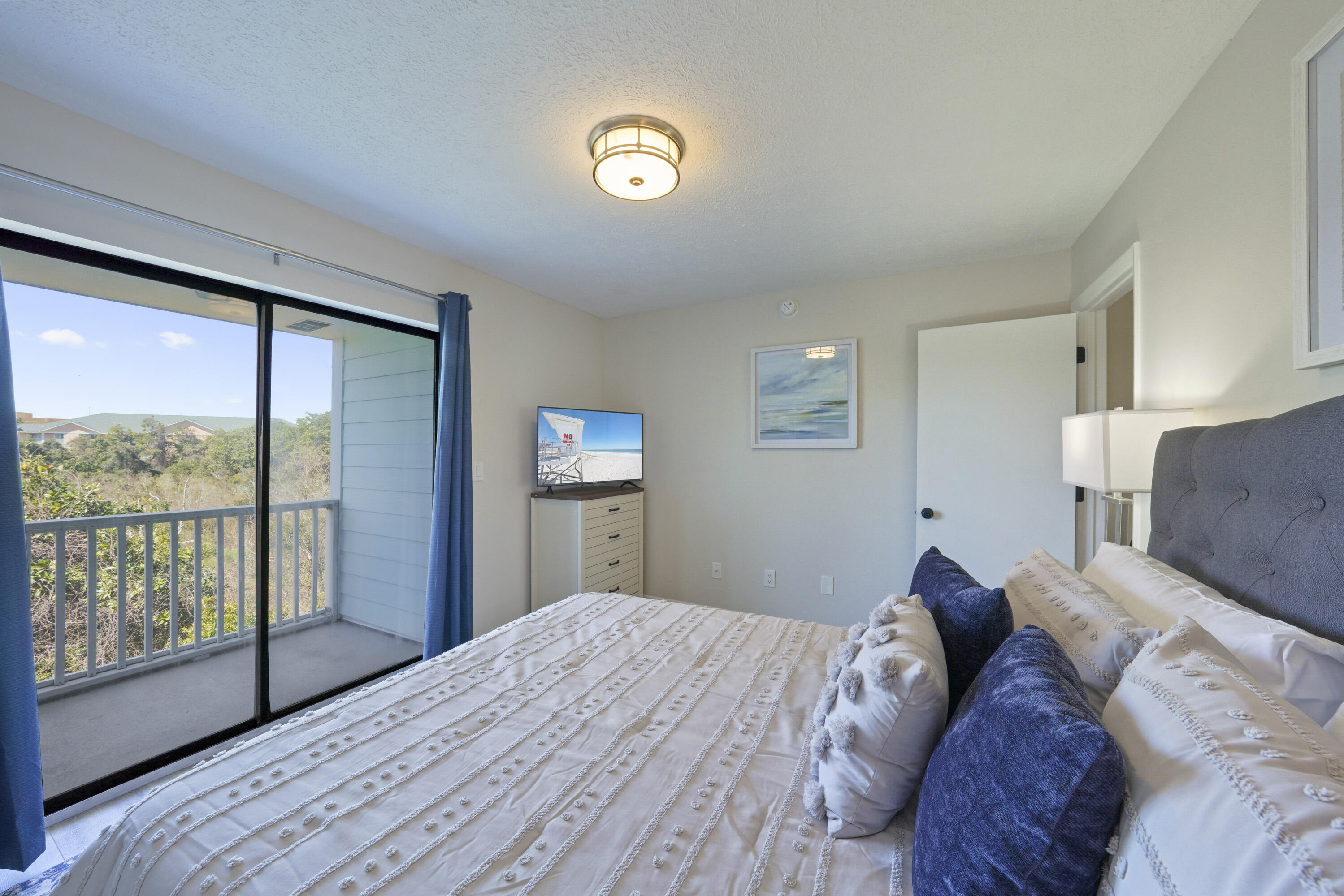 17670 Front Beach Road, Unit H9 Panama City Beach, FL 32413 - Photo 17 of 31 a bed room with a bed and a large window