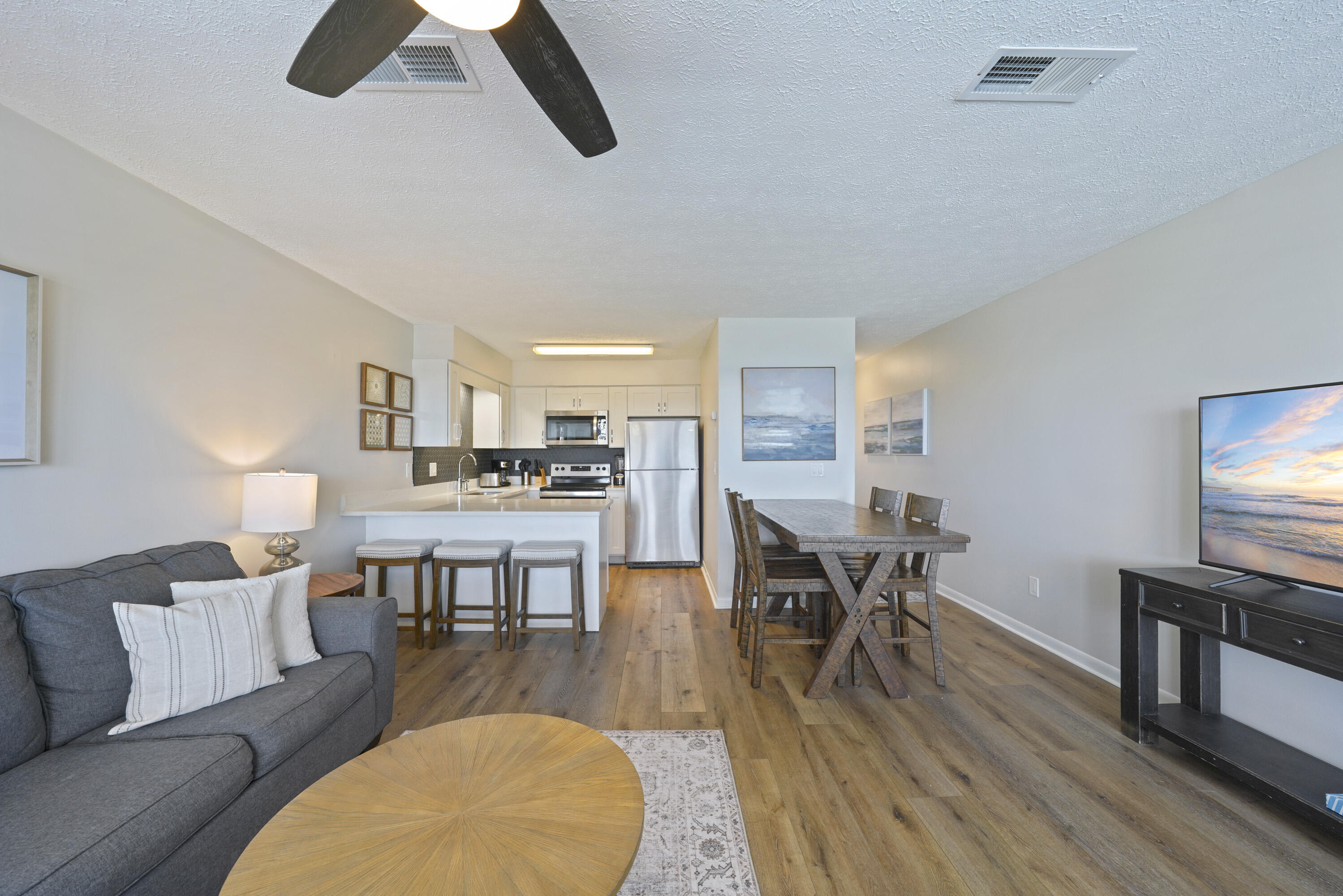 17670 Front Beach Road, Unit H9 Panama City Beach, FL 32413 - Photo 5 of 31 a living room with dining room and wooden floor