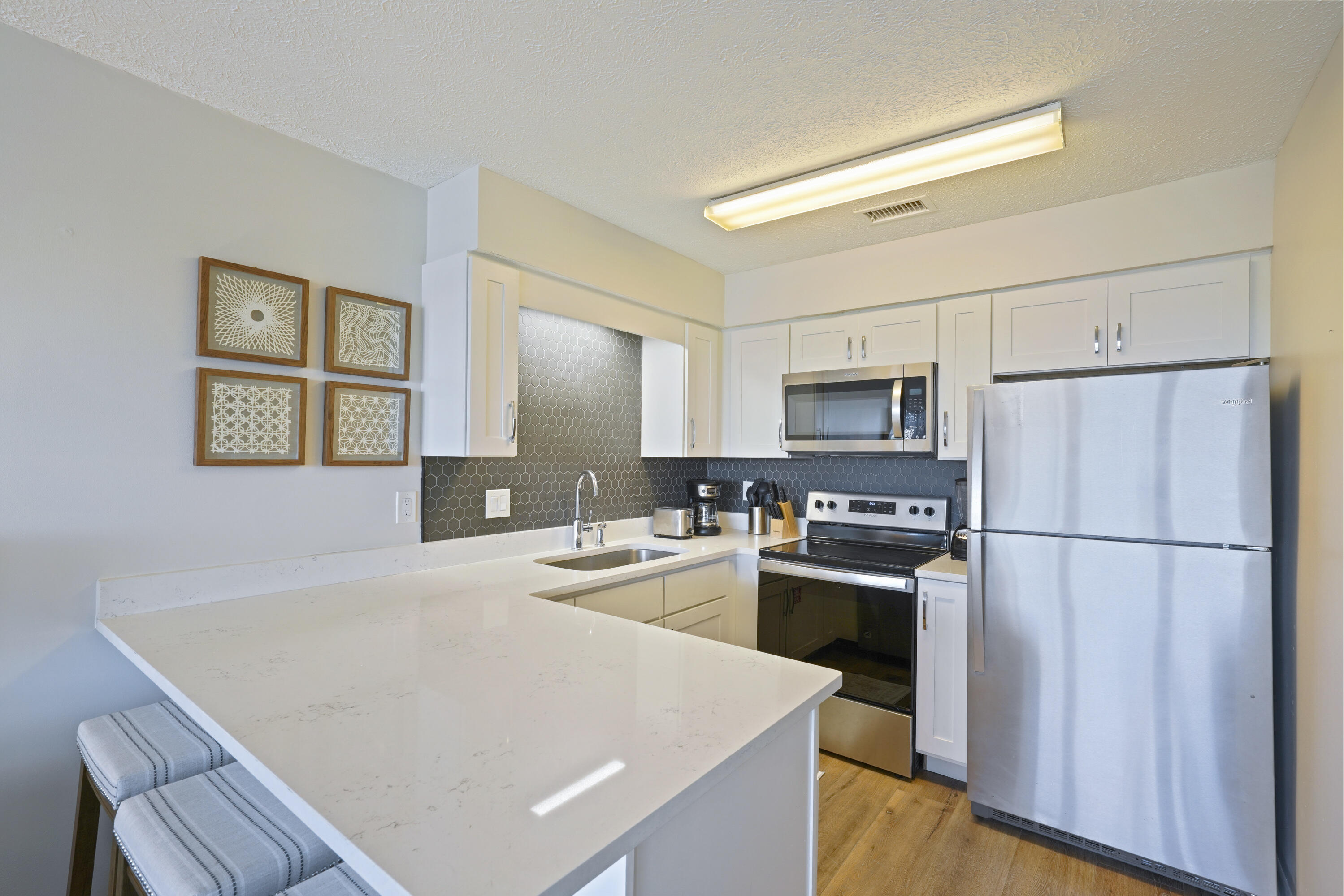 17670 Front Beach Road, Unit H9 Panama City Beach, FL 32413 - Photo 8 of 31 a kitchen with stainless steel appliances a refrigerator stove microwave and sink