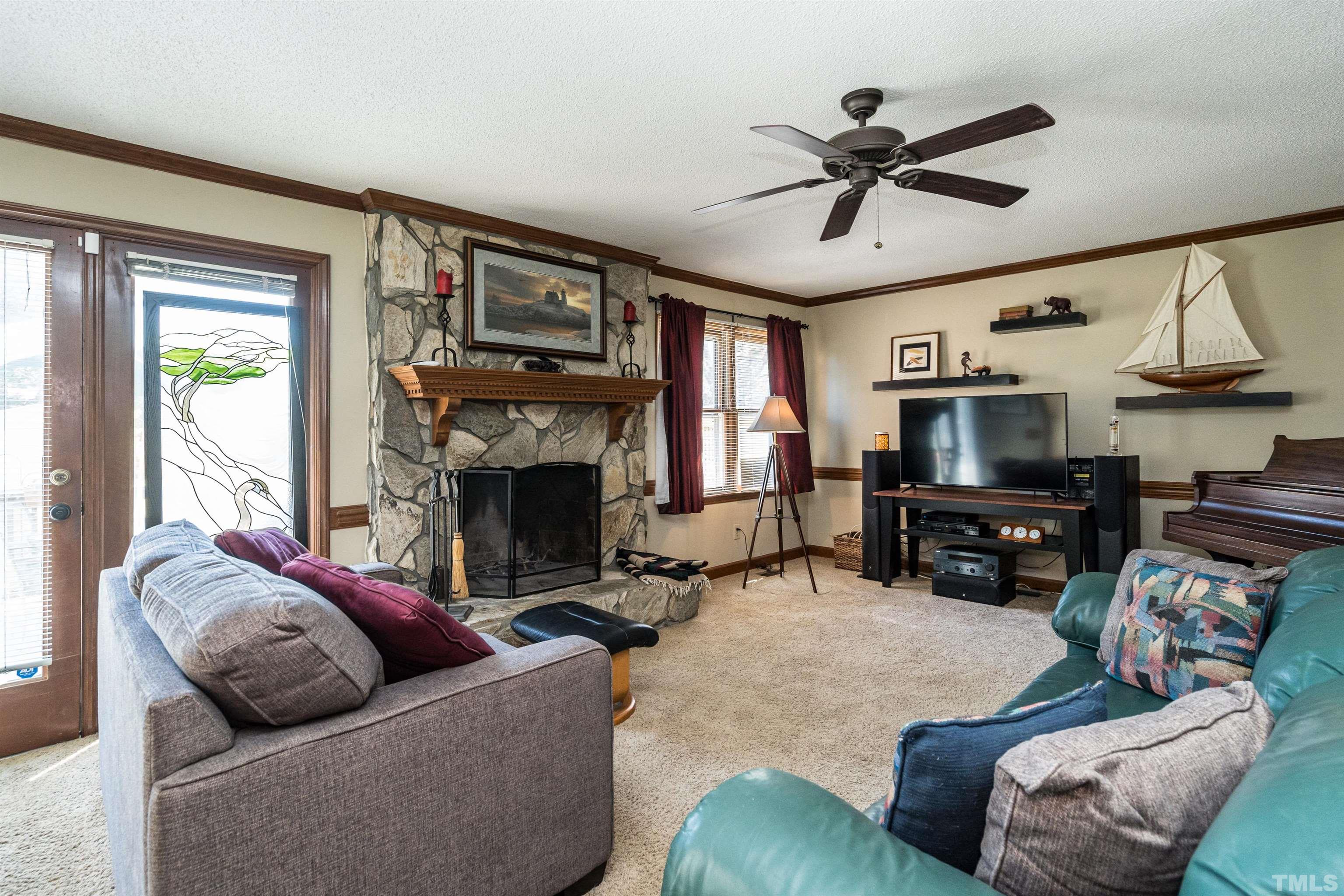5929 Hampton Ridge Road Raleigh, NC 27603 - Photo 7 of 27 a living room with furniture a fireplace and a flat screen tv