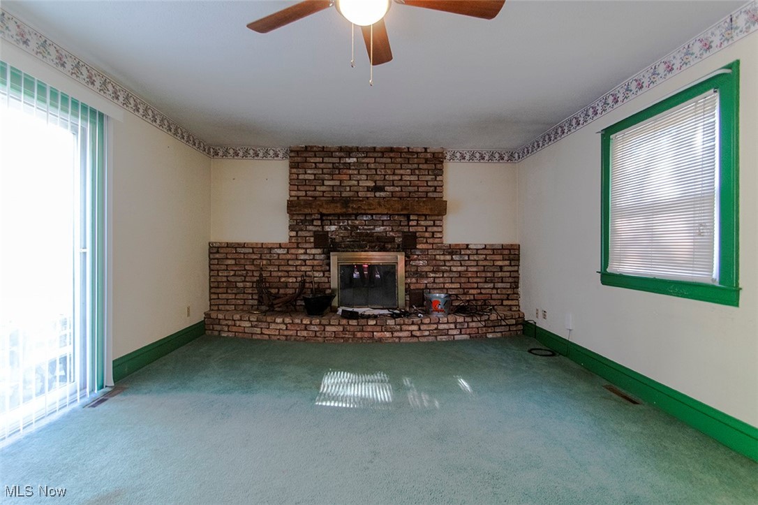 3555 Marks Road Medina, OH 44256 - Photo 4 of 19 Unfurnished family room featuring ceiling fan, carpet, and a brick fireplace